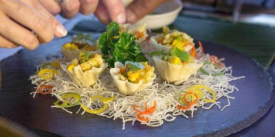 Thai cooking class concept close-up of hands making traditional Thai dish name Krathong Thong or minced chicken and sweet corn in crispy golden cup.