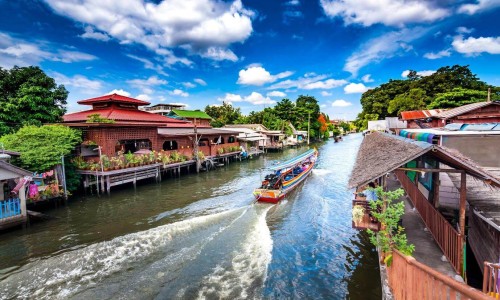 Tourist boat travelling in canal in Bangkok Thailand