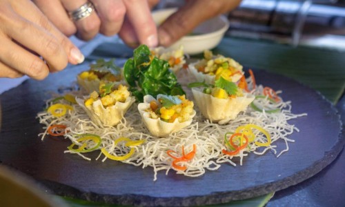 Thai cooking class concept close-up of hands making traditional Thai dish name Krathong Thong or minced chicken and sweet corn in crispy golden cup.